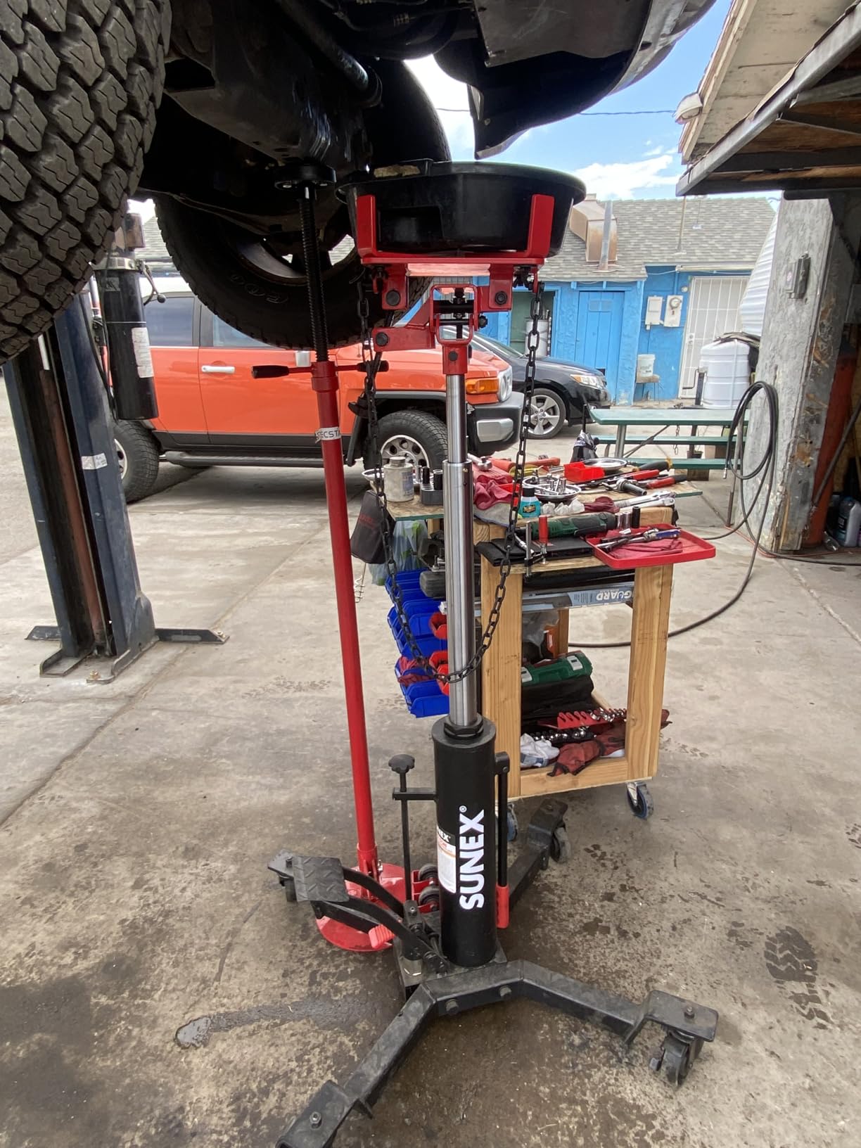Sunex Tools 7793B 1,000 lb Telescopic Transmission Jack, Hydraulic, Foot Pump Operated, Tilt Saddle with Chain Tie-Down, 74.2 in Max Height customer photo 1